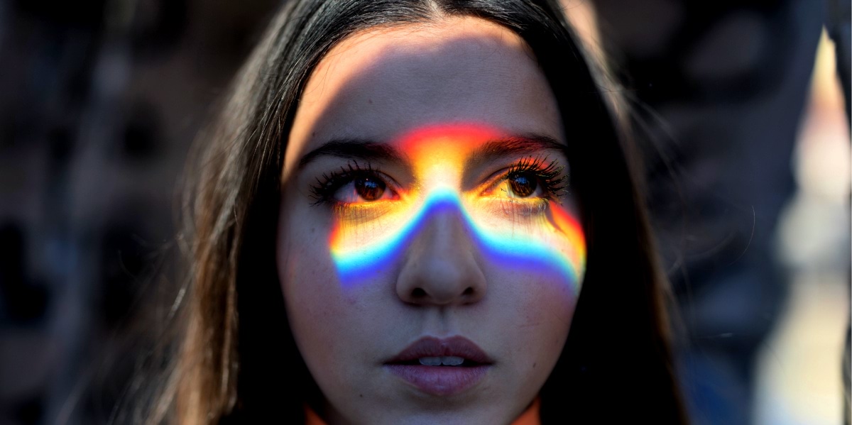 A Girl Seeing The Sky With The Reflection Of A Rainbow In Her Face