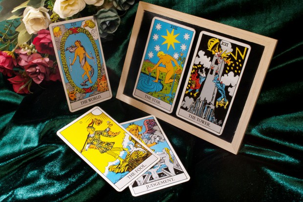 Tarot cards and flowers on a  green table