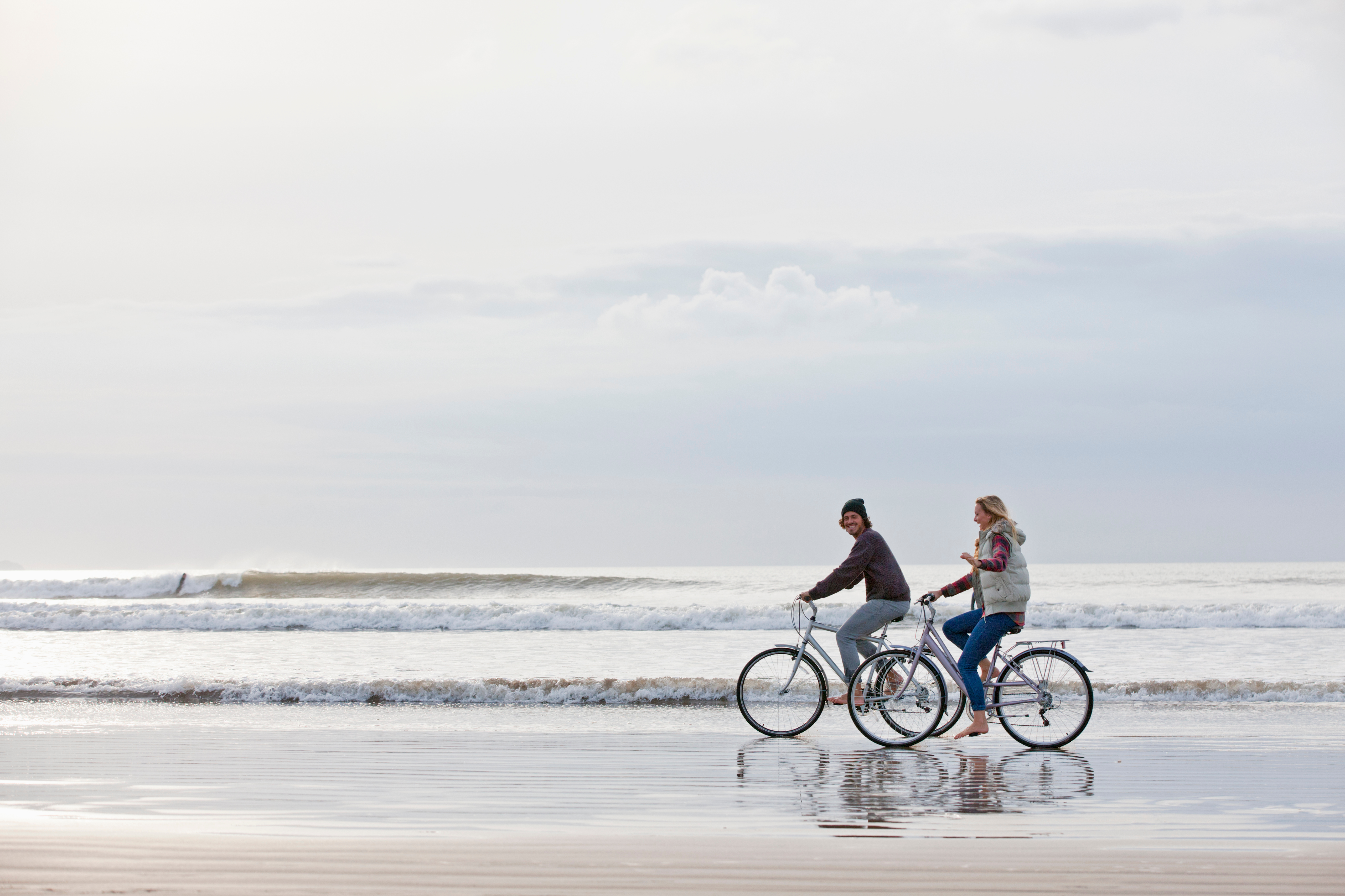 Couple cycling on sea shore
