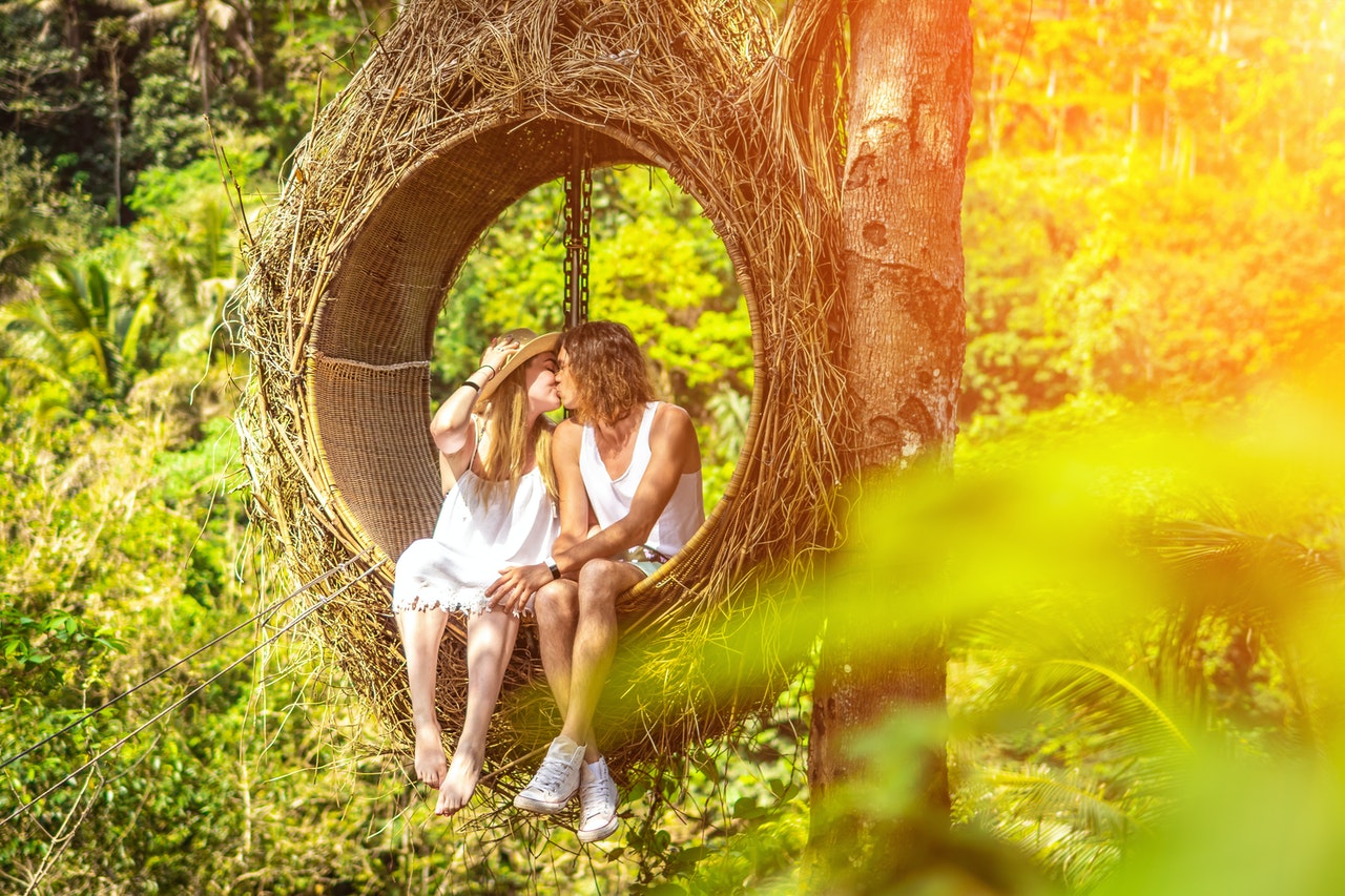 Selective Focus of Kissing Couple in a nest swing