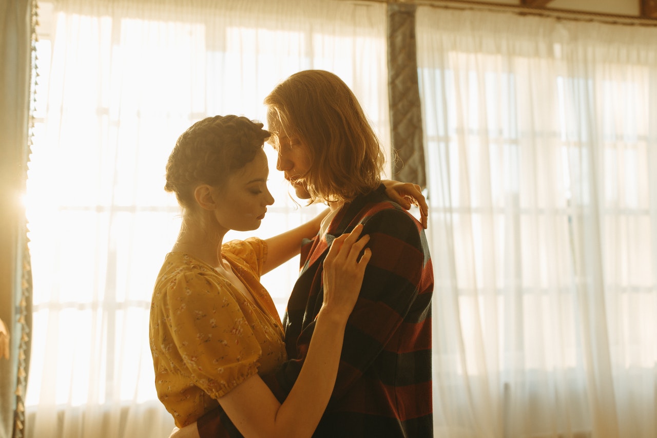 A Couple Hugging In A Room With A Backlit by the Sunlight