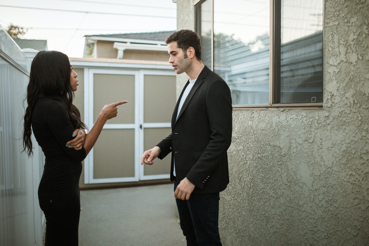 Man in Black Suit Standing Beside Woman in Black Dress arguing about something