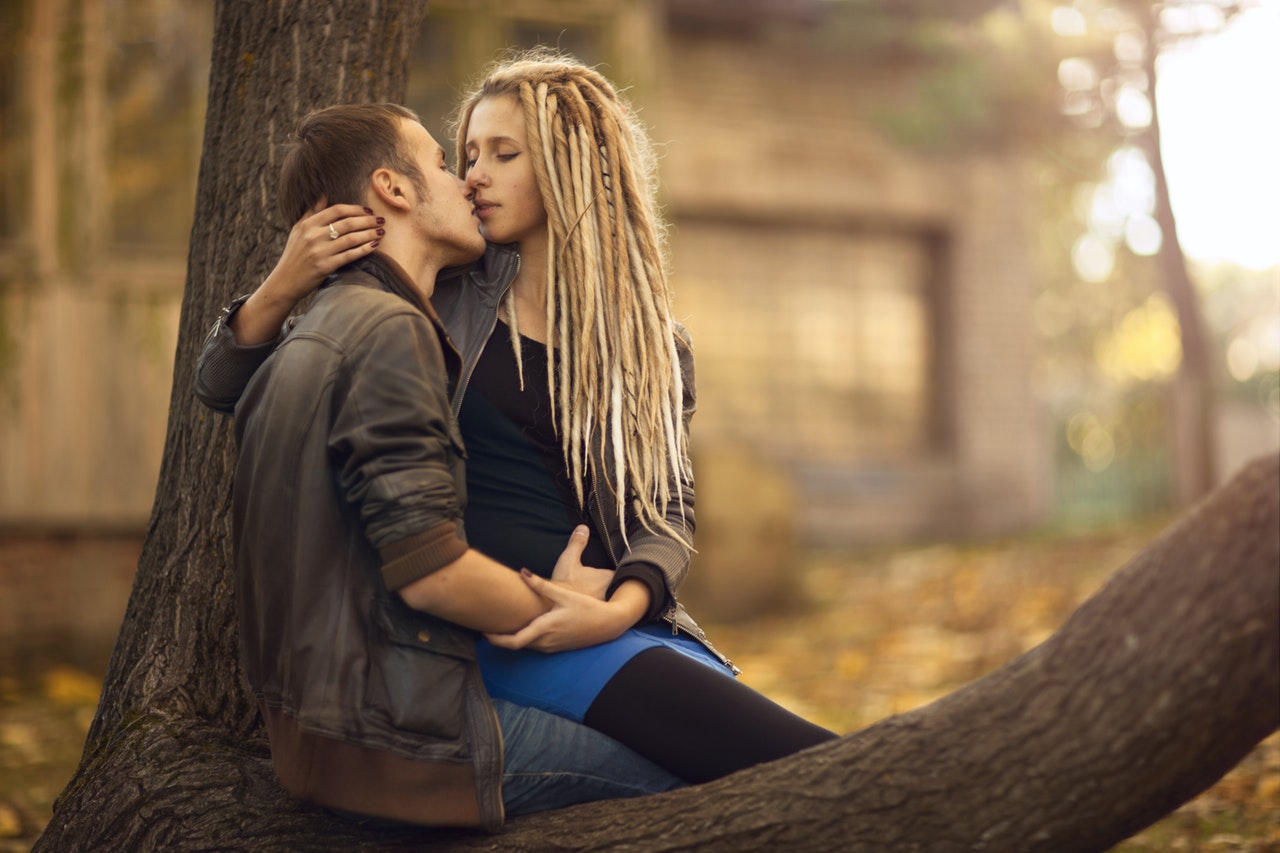 A Couple Sitting on a Tree Kissing