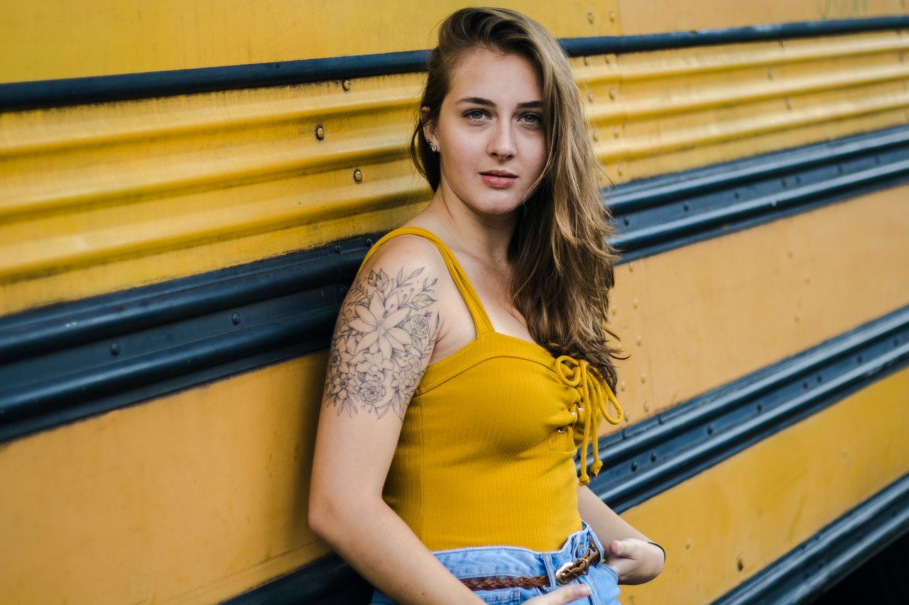 Woman With Arm Tattoo Wearing Yellow Lace-up Tank Top