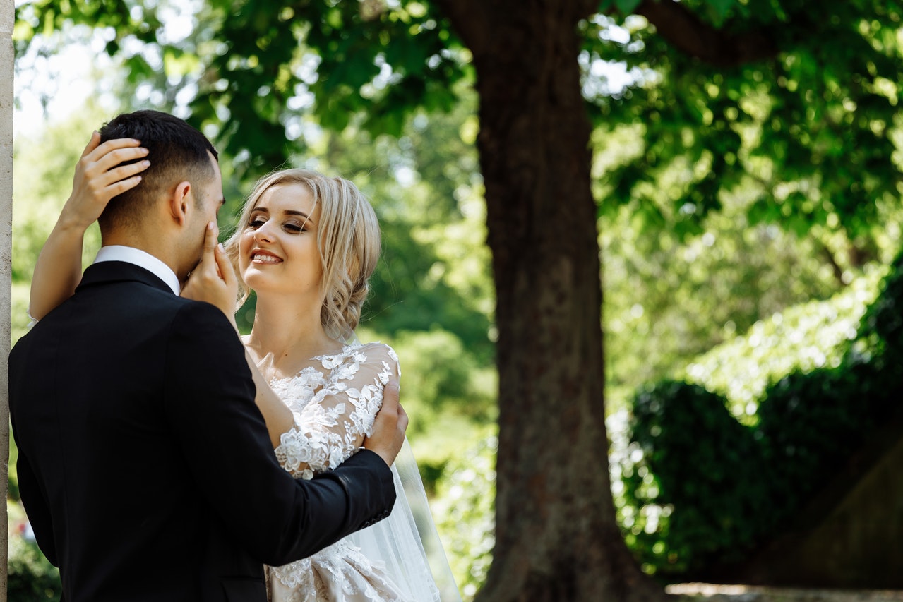 Couple Standing Under Tree in wedding attire