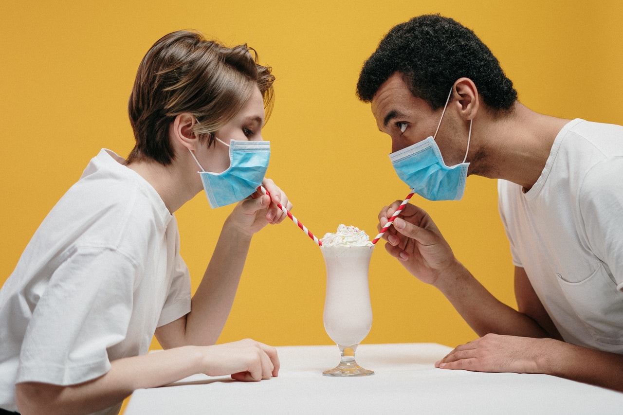 Couple Wearing Face Mask Drinking Milkshake both wearing white shirt