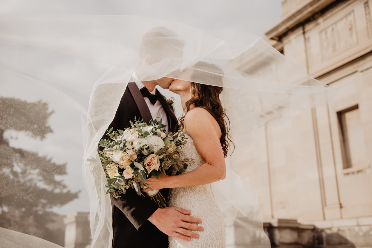 Man And Woman Kissing wearing wedding attire