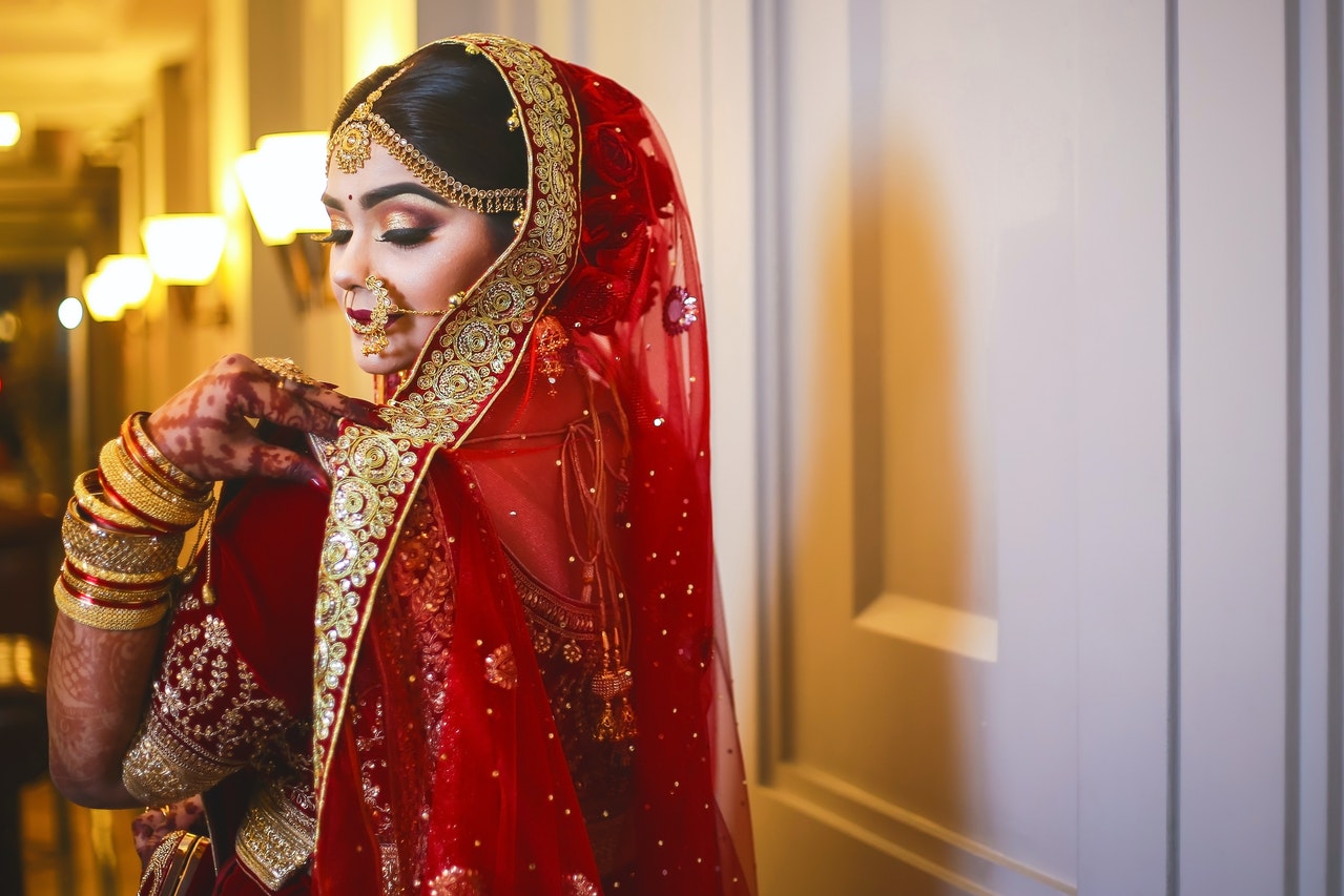Indian Girl In a comlete Indian Wedding Dress in a hallway with lights on