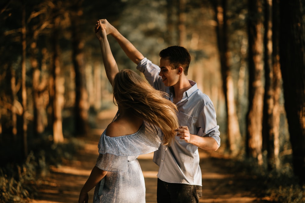 A man and woman dancing in the forest