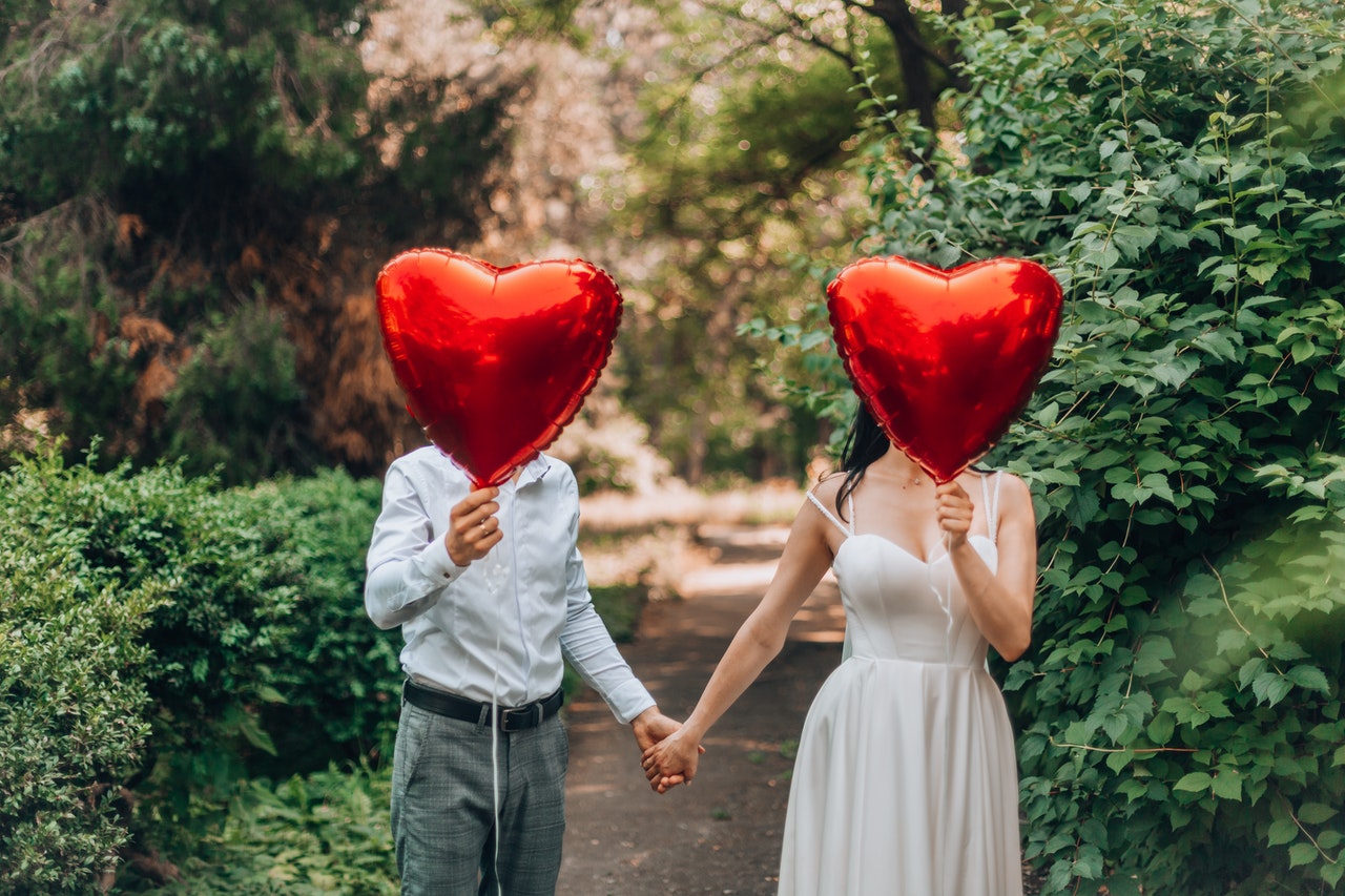 A Couple Holding Heart-Shaped Balloons
