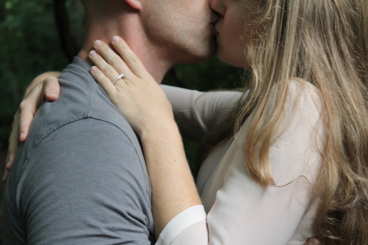 Man and Woman Kissing with an engagement ring on the womans finger