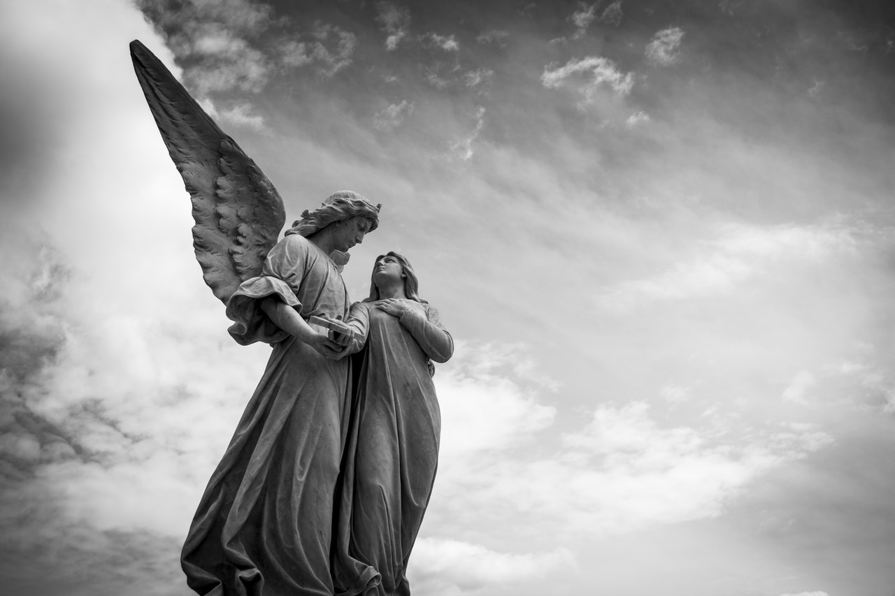 Statue of an Angel holding hands with a person and looking at each other