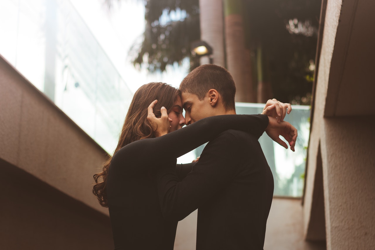 Man and Woman About to Kiss Each Other both wearing black