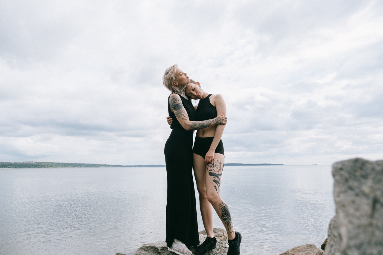 Women Hugging while standing on a rock