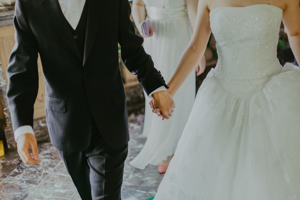 Groom and bride walking while holding each other's hand