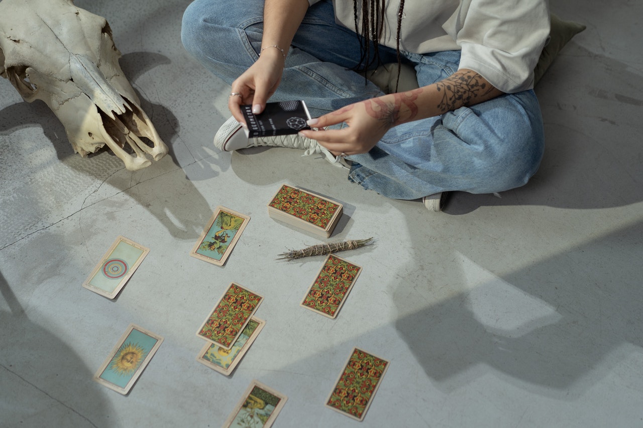 A Woman Reading Tarot Cards While Sitting on the Floor