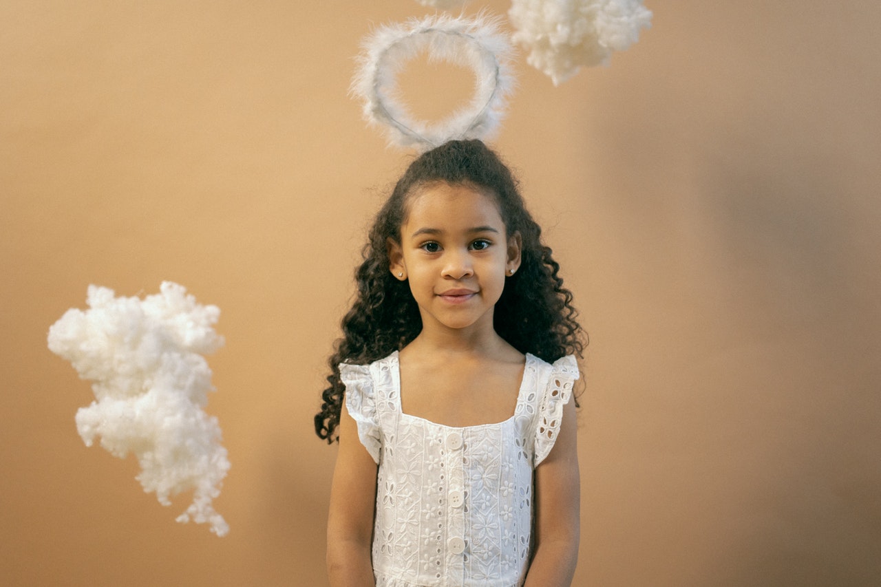 Adorable black girl in angel outfit with nimbus