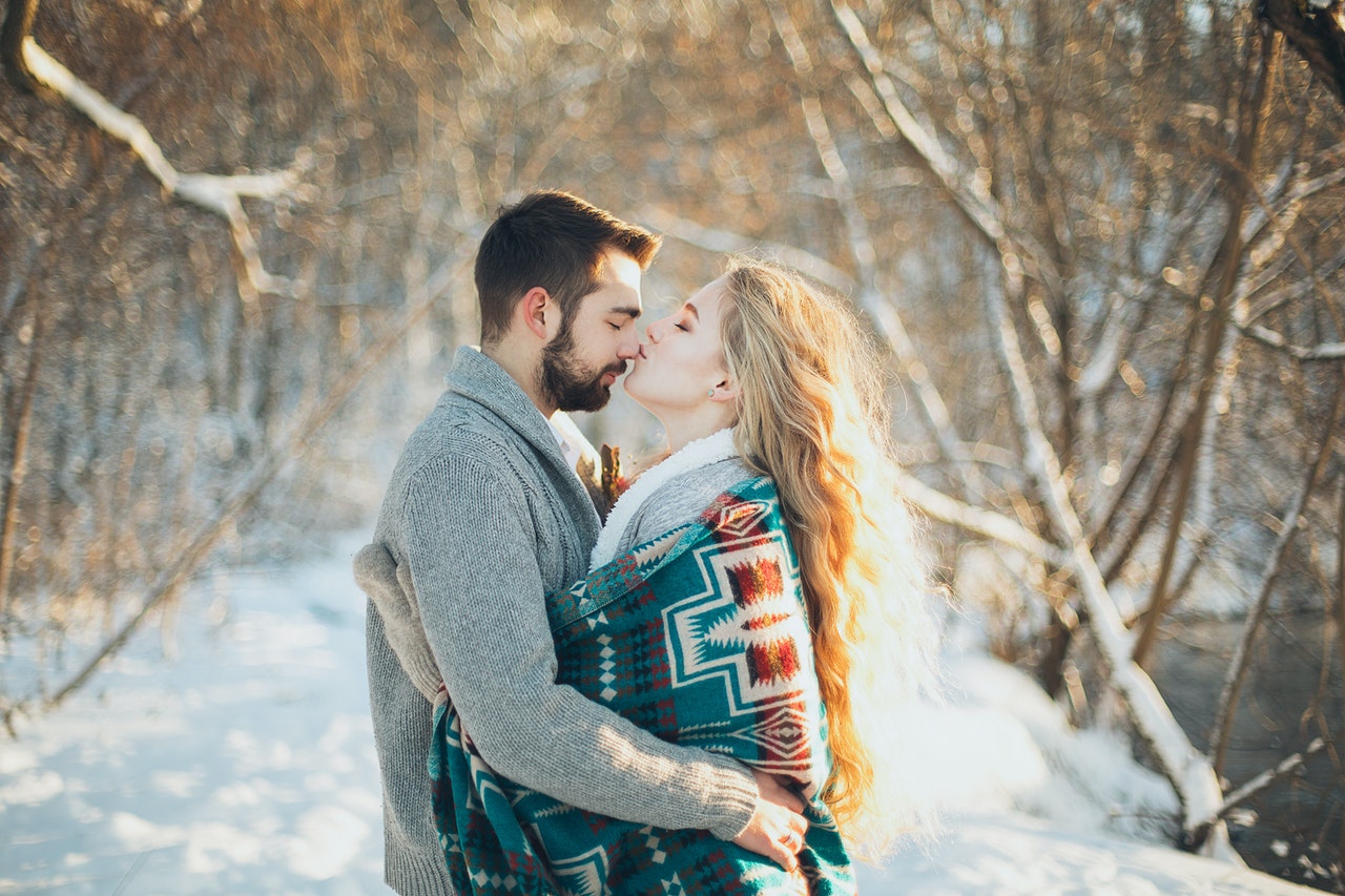 Man and Woman Hugging Each Other And Are About to Kiss during Snow Season