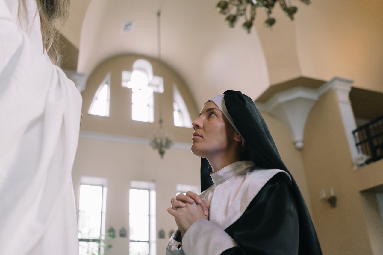 A Nun Kneeling To Pray