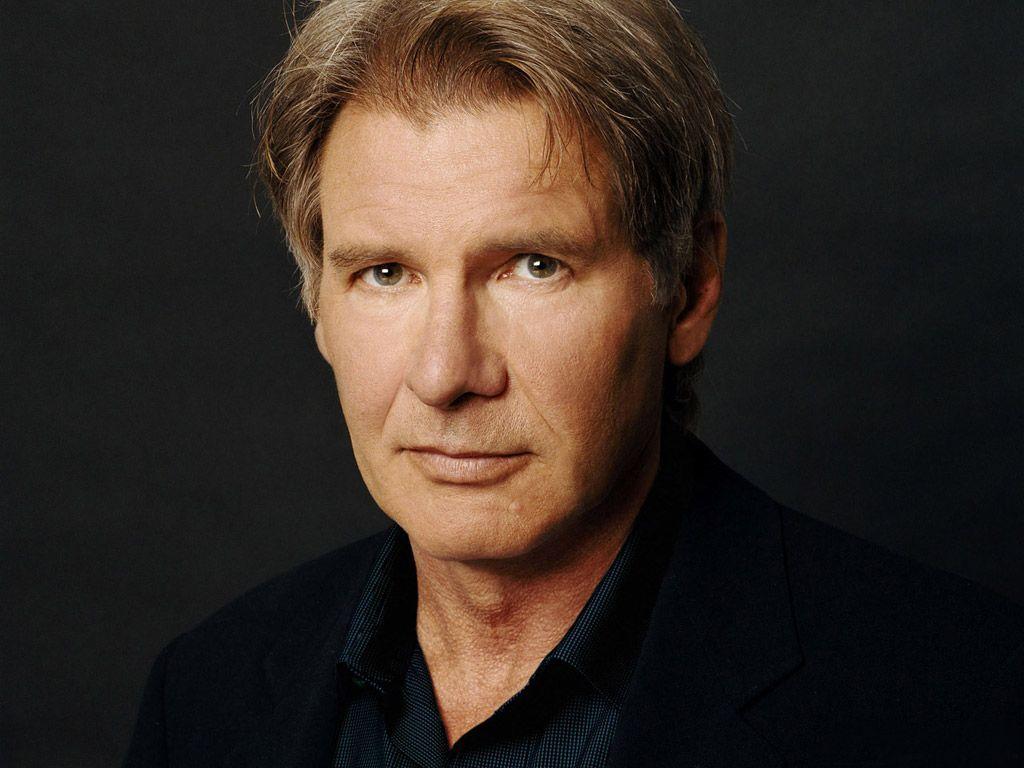 Harrison Ford wearing a black coat with a serious face expression