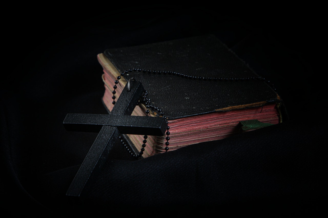 Black Cross Leaning on Black Hardcover Bible