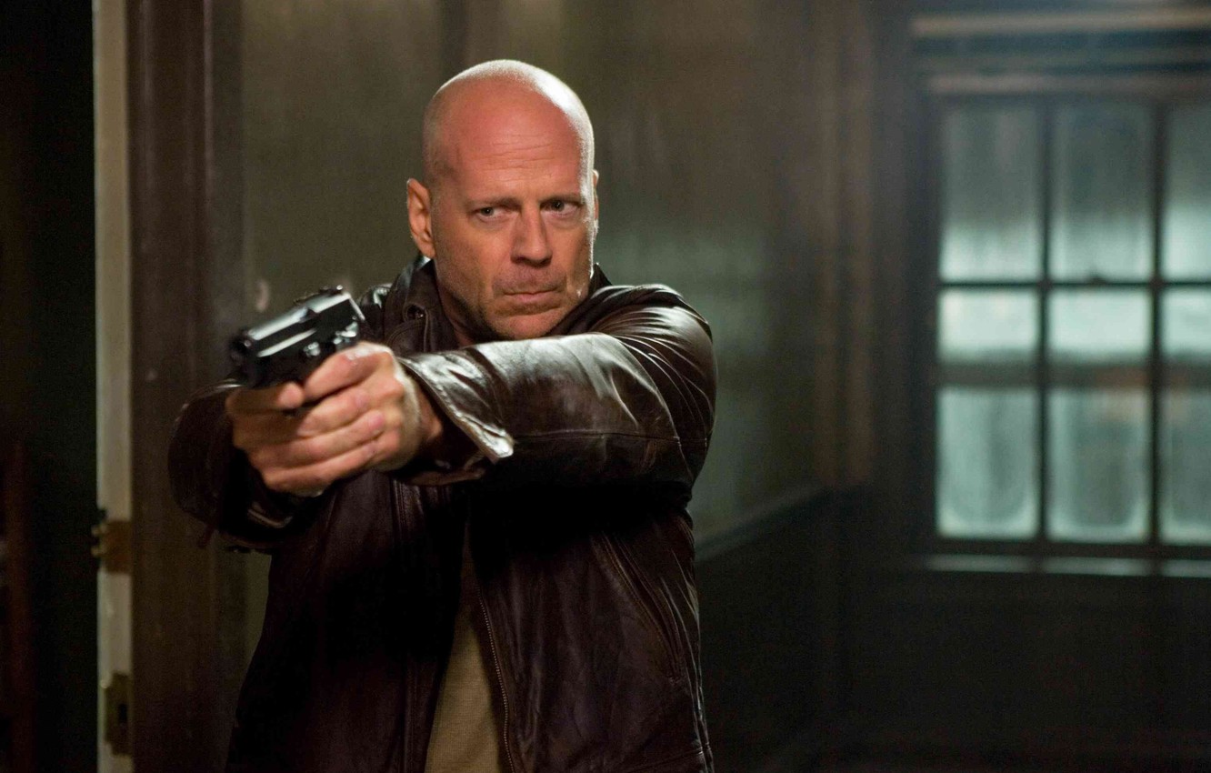 Bruce Willis looking fierce while holding a gun with his both hands