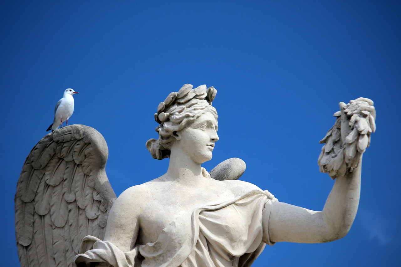 Bird Perching on Angel Sculpture