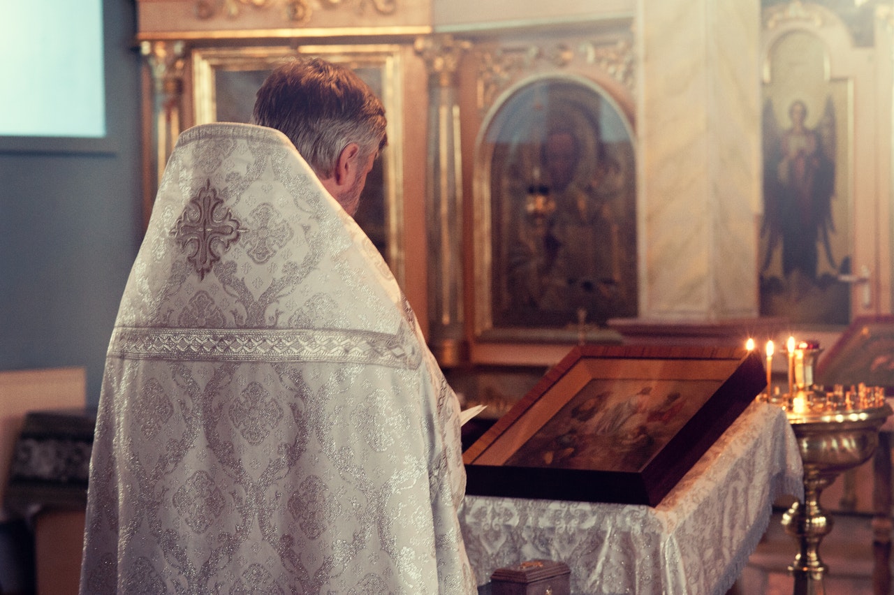 Priest Standing In Front Of Altar In The Church