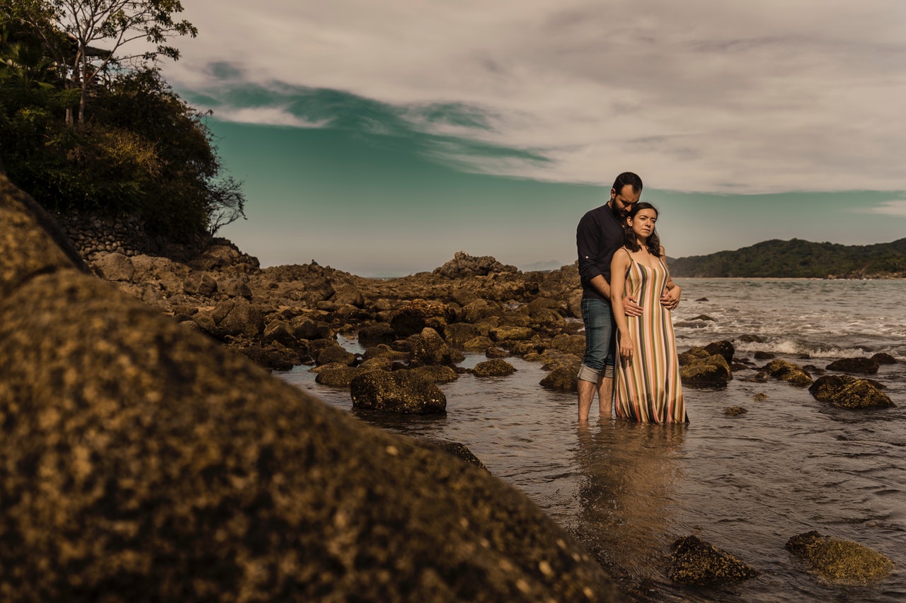 Sweet Moments Of A Romantic Couple Standing On Rocky Beach