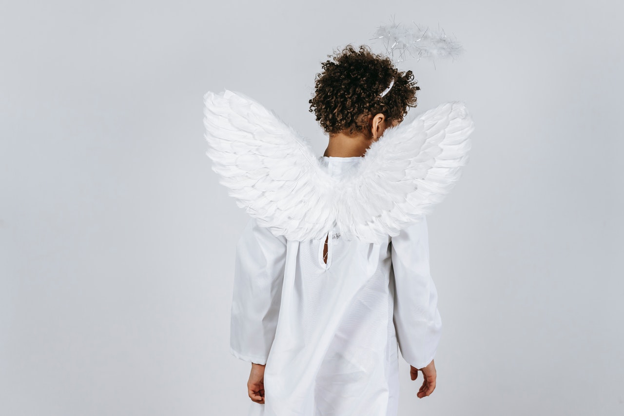 Child in costume of white angel with gentle wings