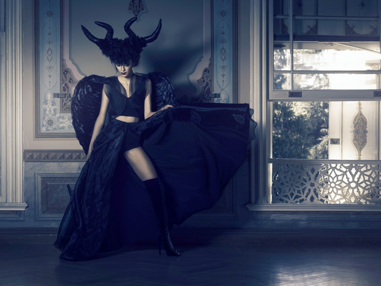 Woman In Black Dress With Angel Wings Standing Near Window