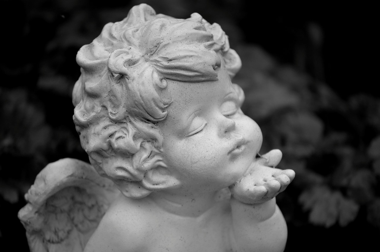 A Baby Angel Statue Blowing A Kiss