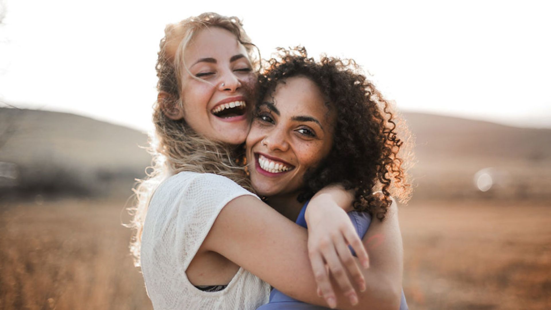 Two woman happily hugging eacg other while smiling