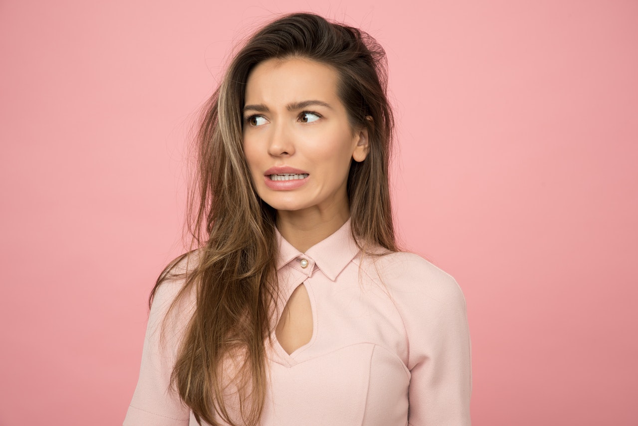 Woman Wearing A Pink Top With Worried Expression