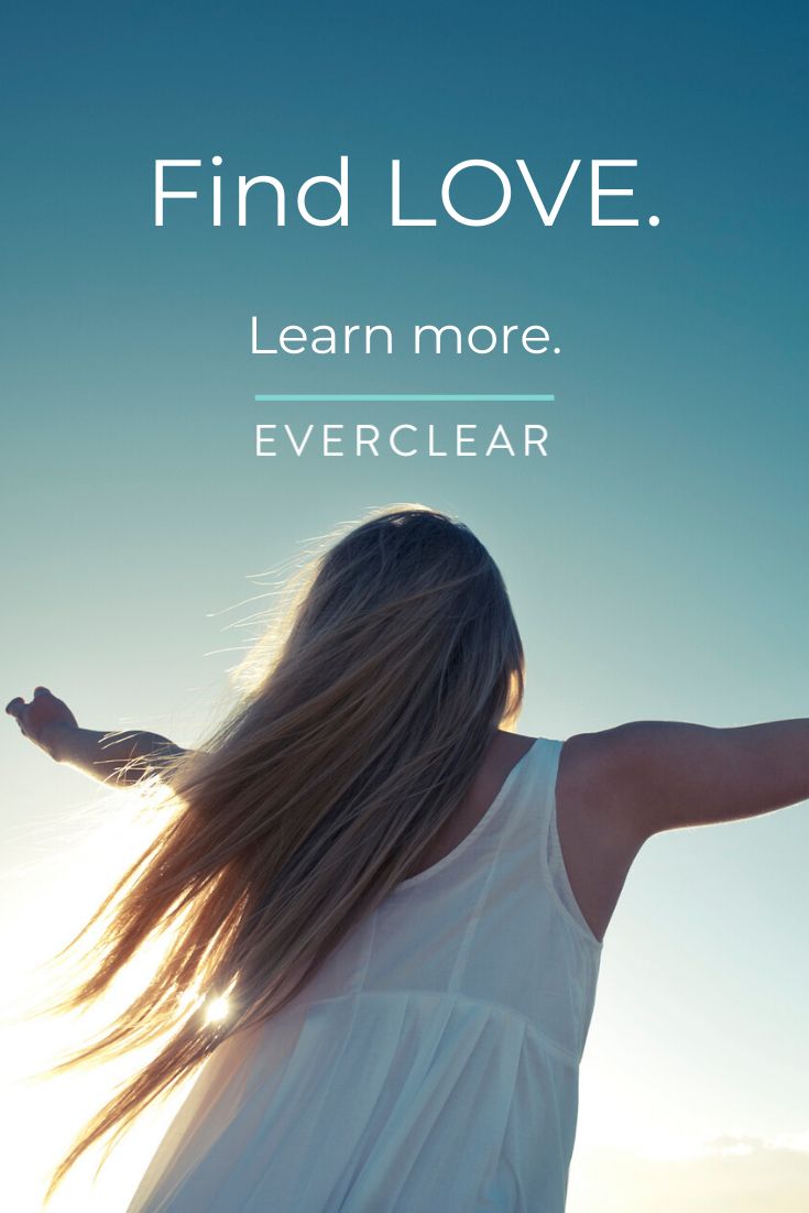 A woman wearing a white dress looking at the sky with her hands on the air and everclear logo on top