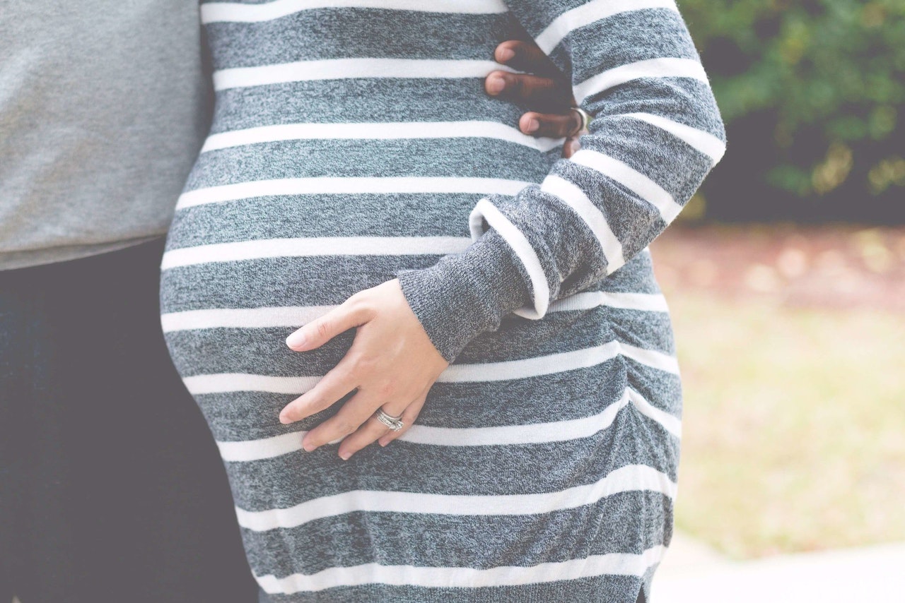 Woman Wearing a Gray and White Striped Maternity Dress