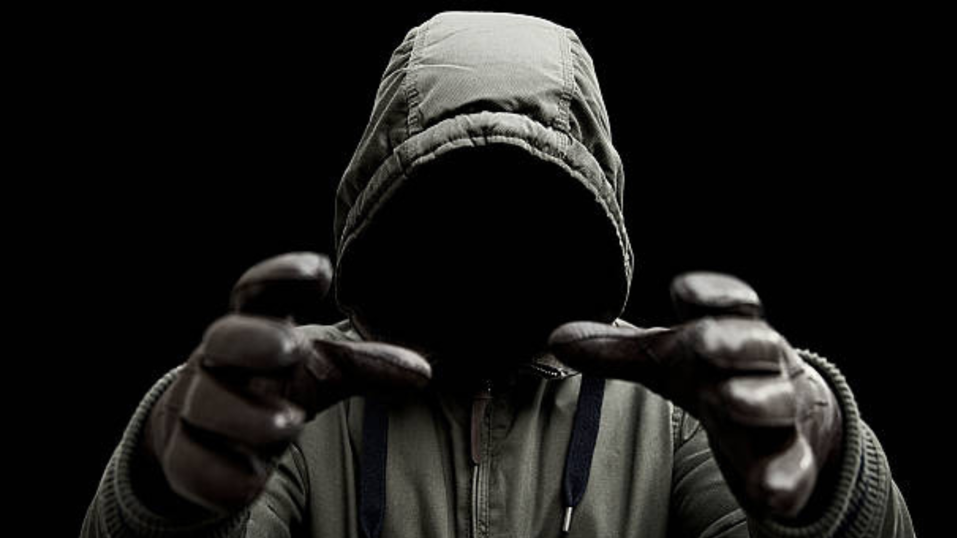 A man wearing a hoodie with no face and about to strangle someone