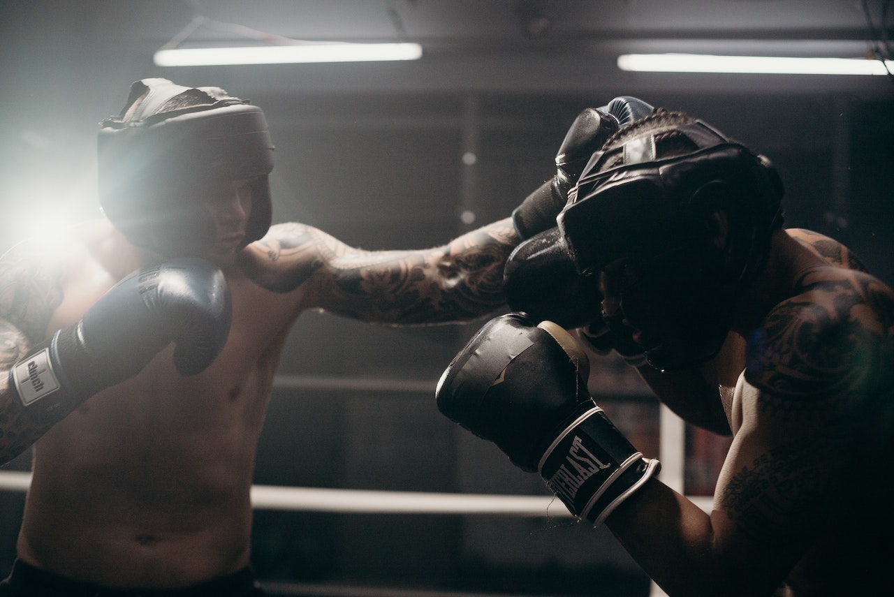 Men wearing black boxing gloves while fighting