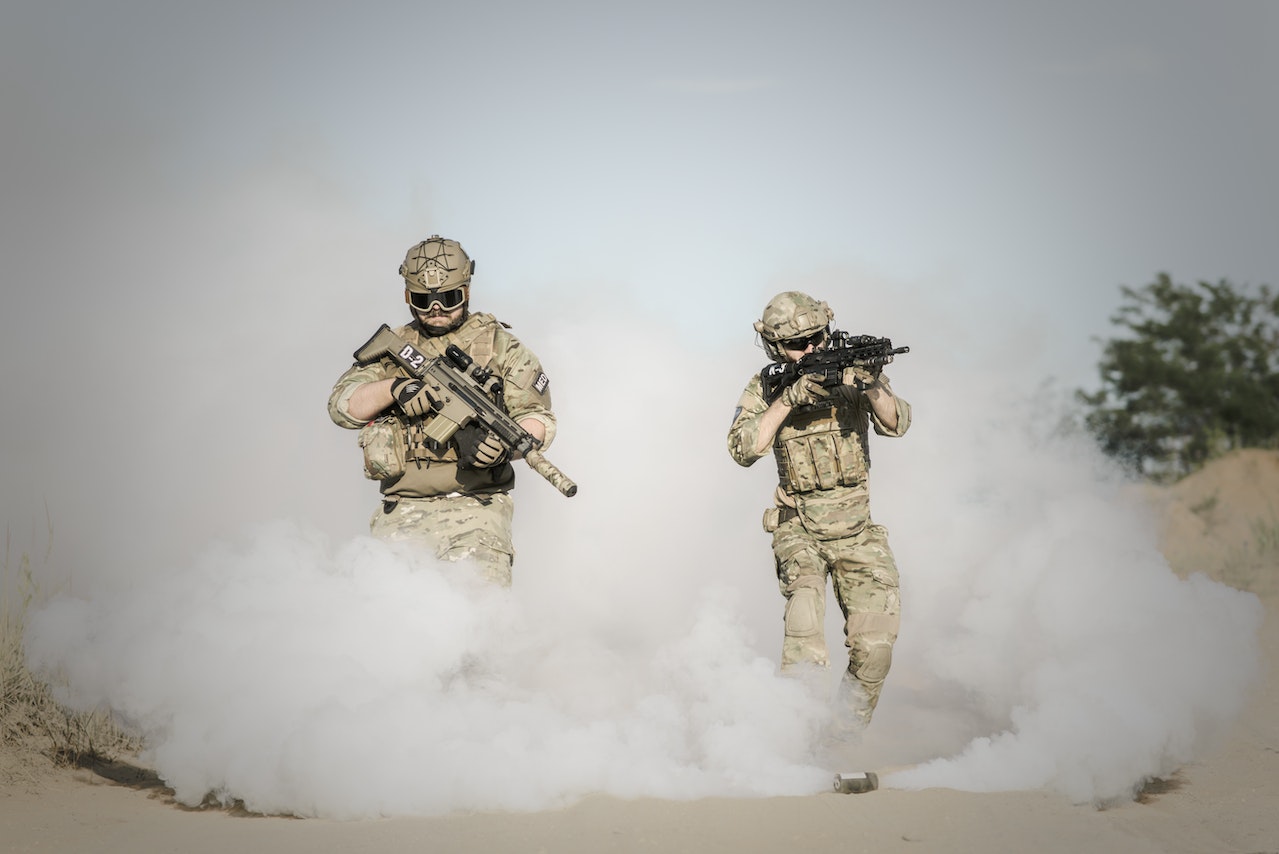 Men Holding Rifle While Running Through Smoke Grenade