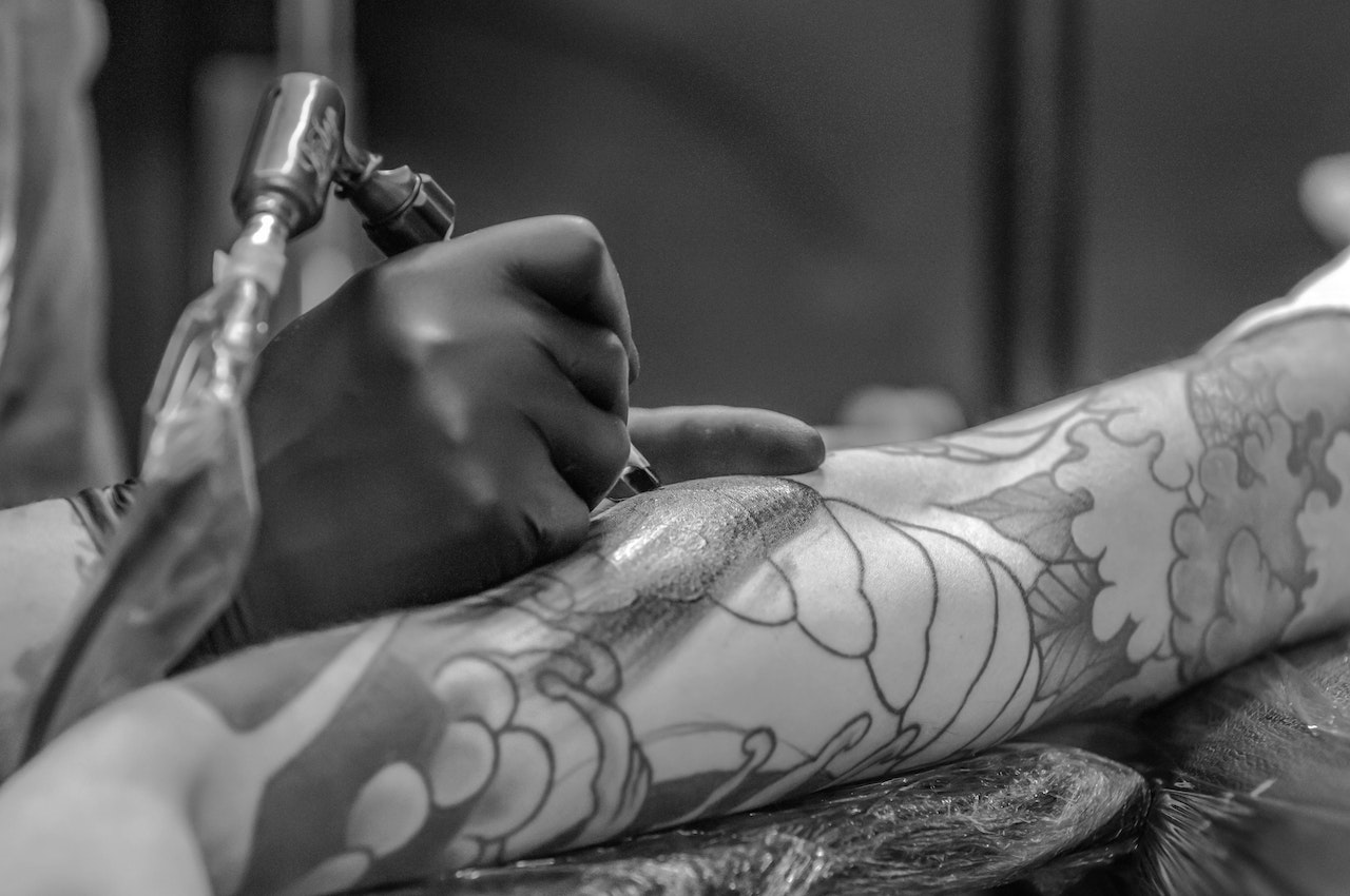 Person Applying Tattoo On Arm