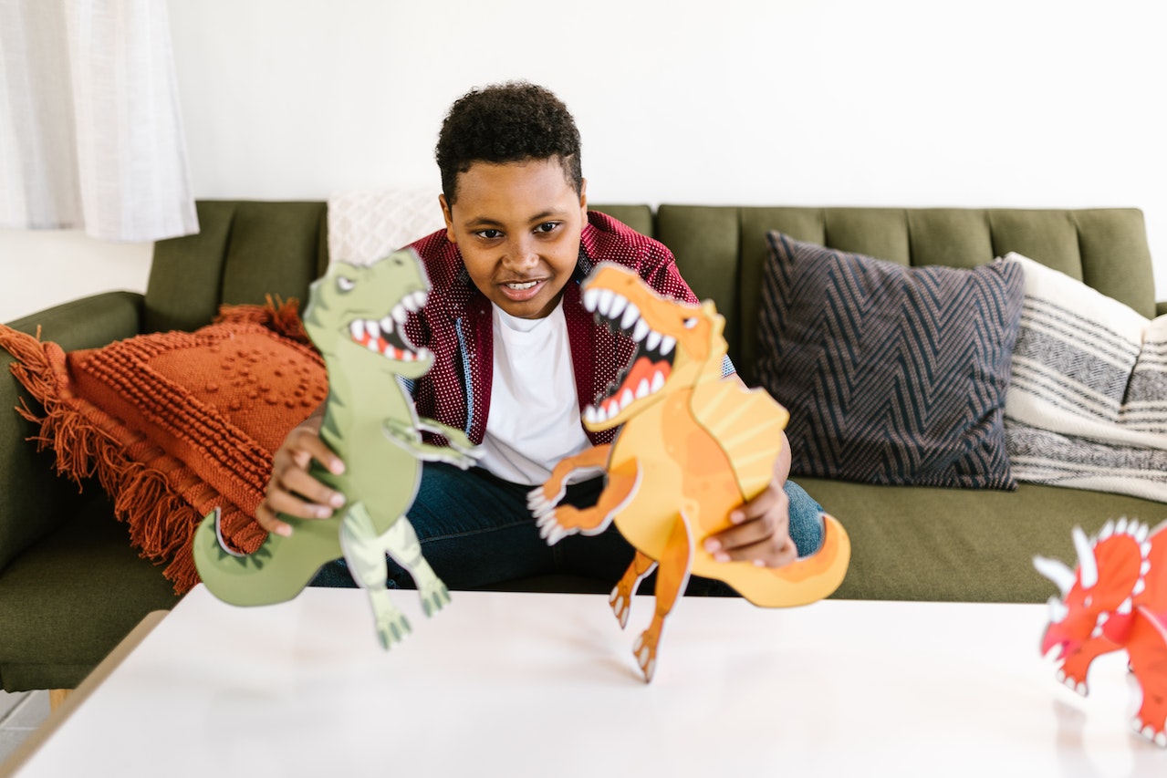 A Boy Playing with Dinosaurs