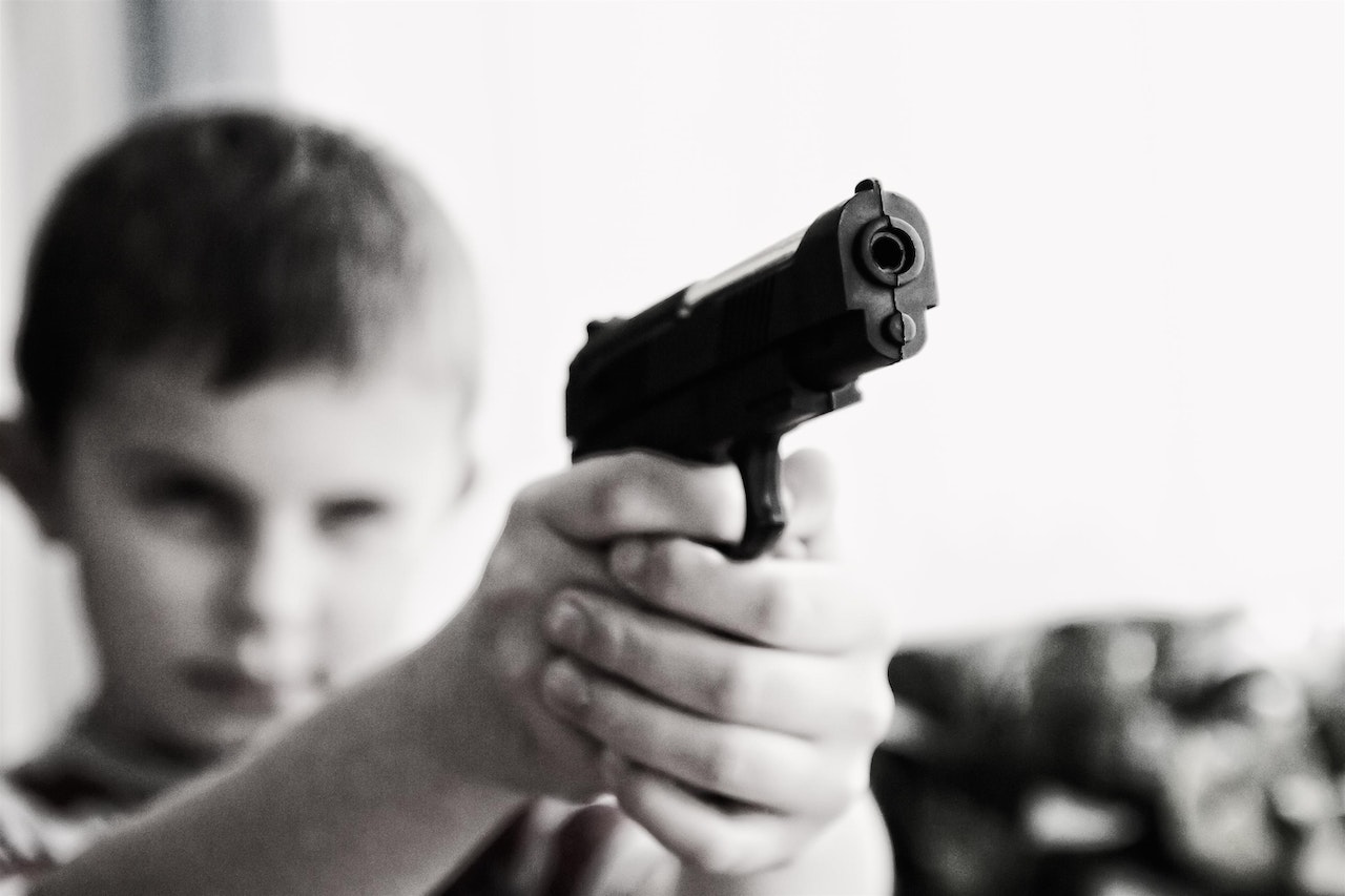 A boy pointing a gun at someone or something