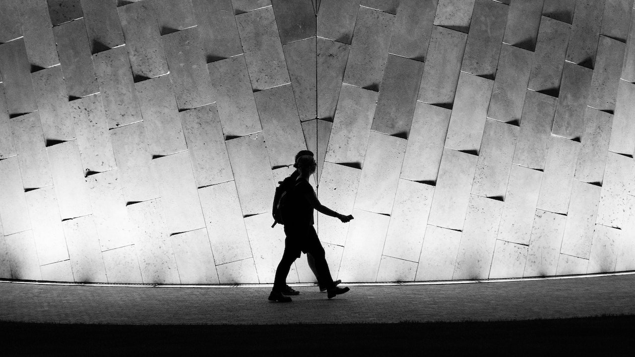A Person Walking Near An Illuminated Wall