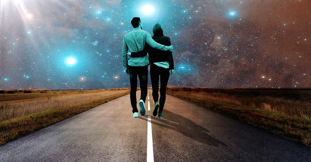 Man and woman walking in the road under the stars