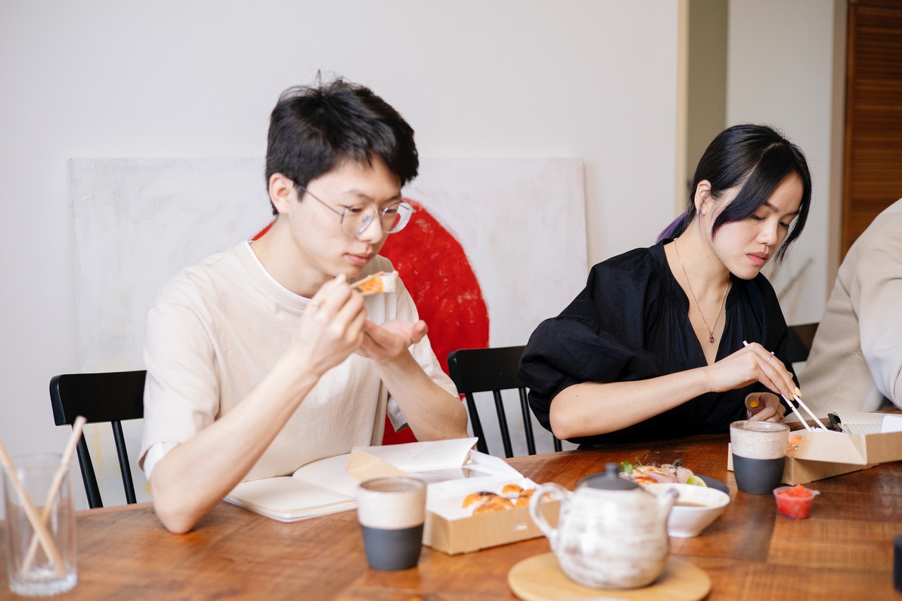 Man and Woman Eating with Chopsticks