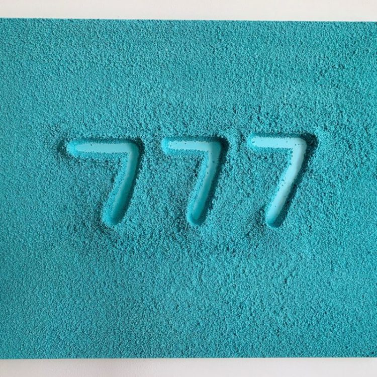 777 number traced in a blue sand
