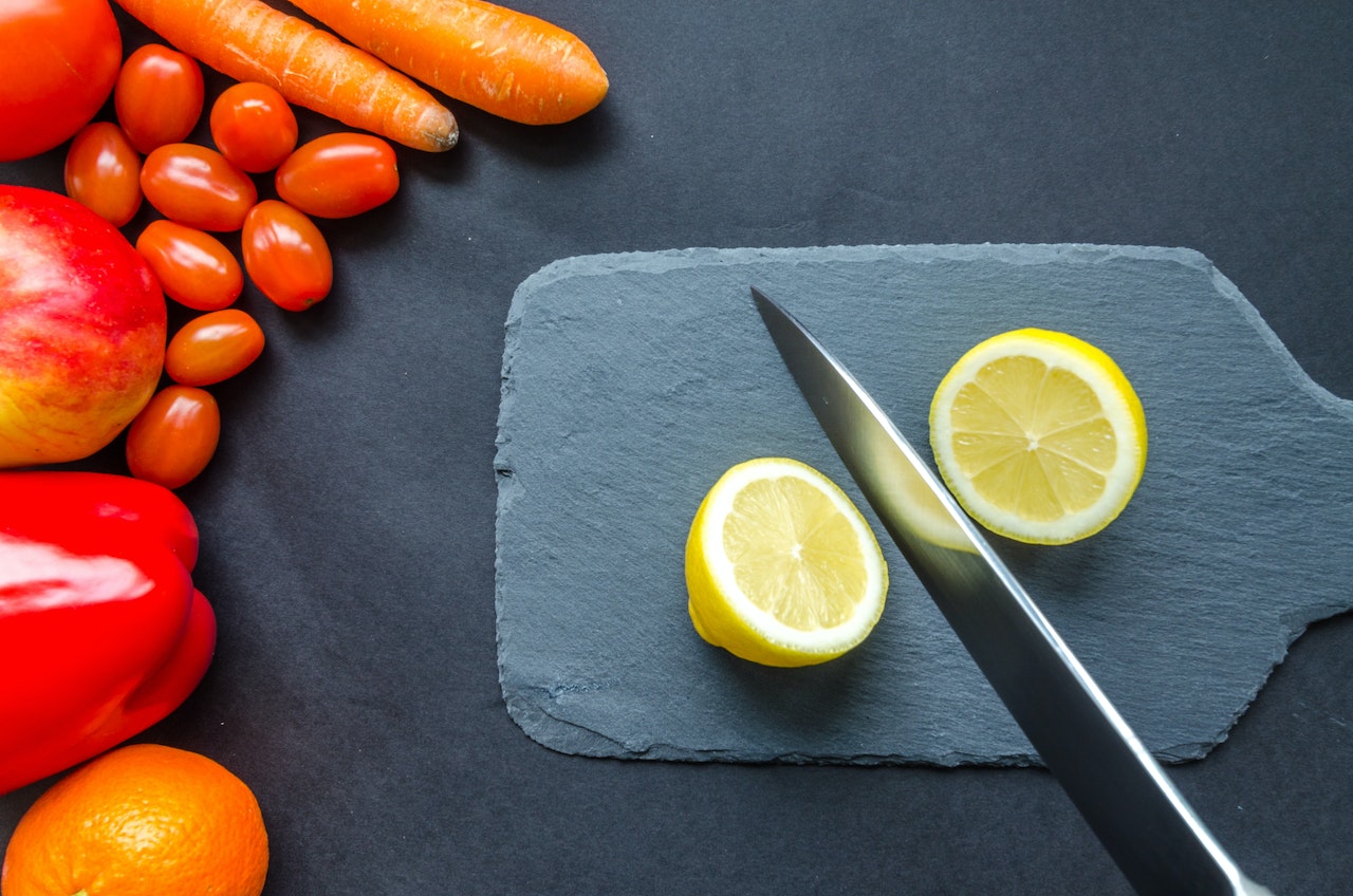 A knife sliced the lemon on the grey chopping board