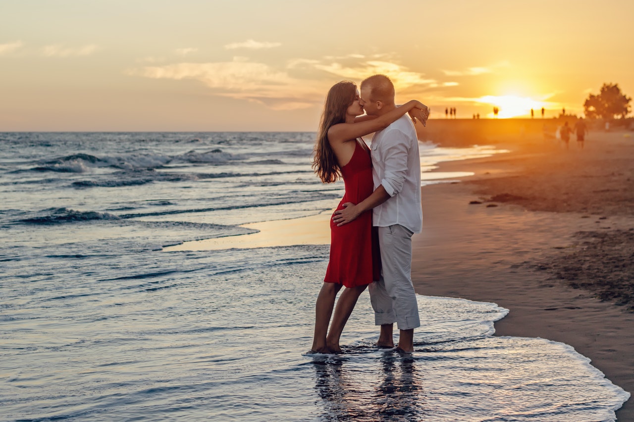 Couple Kissing on Beach during Golden Hour