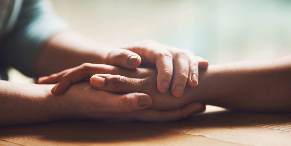 Two people holding hands and praying