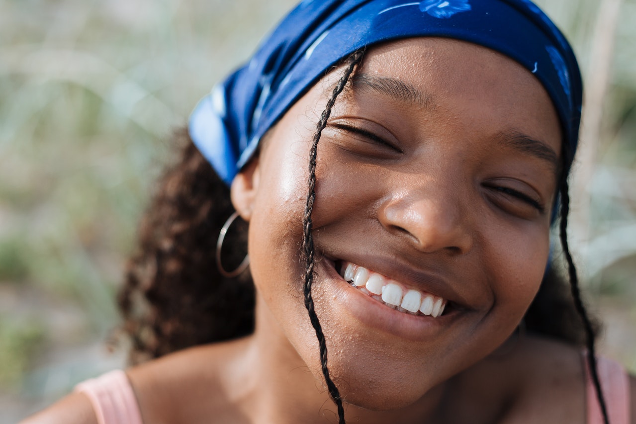 A girl wearing a blue bandana while smiling